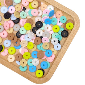 close up of 12mm silicone spacer beads showing smooth flat round shape and soft texture